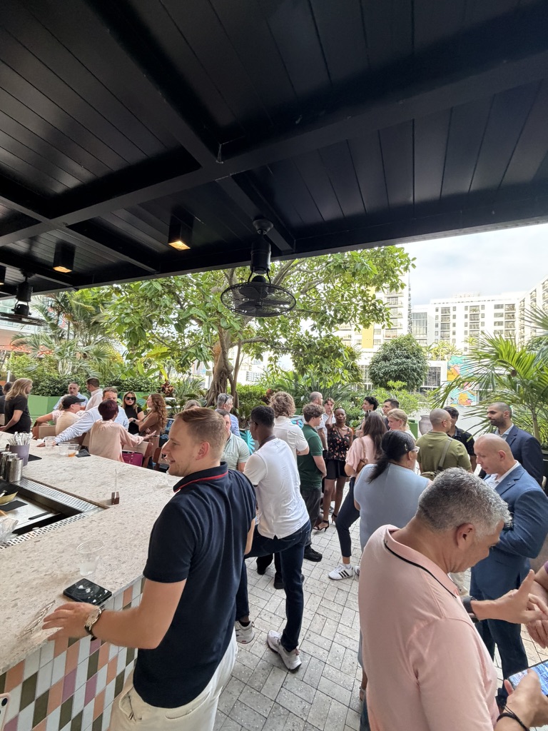 Guests talking in small groups on an outdoor patio at the tech networking event